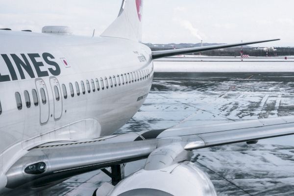 A close-up of an airplane parked at an airport, with visible engine and part of the fuselage featuring the word 